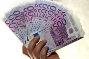 Een hand houdt een waaier van briefjes van 500 euro vast.