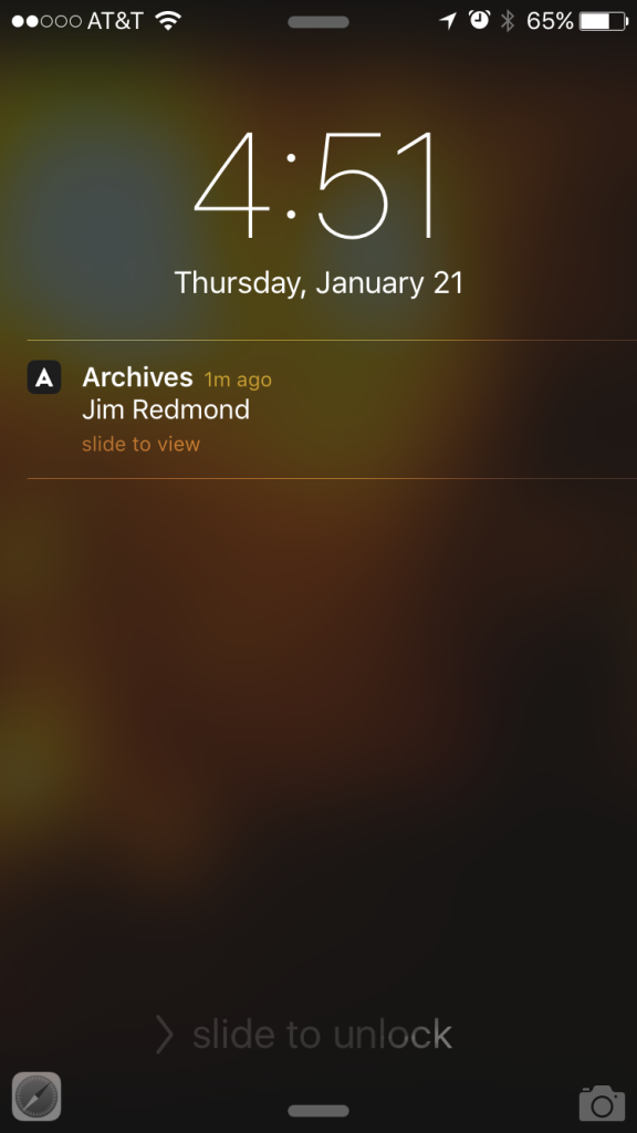 Vergrendelscherm van een iPhone op donderdag 21 januari met een melding van de app Archives: “Jim Redmond”.