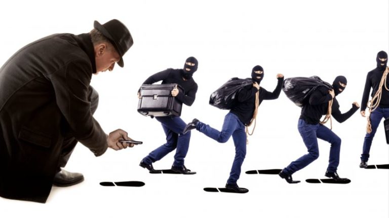 Gestileerde foto van een man in lange jas en hoed die met een smartphone voetafdrukken volgt van vier gemaskerde inbrekers die wegrennen met een koffer en zwarte zakken.