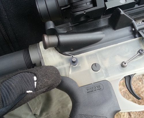Close-up van een AR-15 met een doorschijnend wit, geprint onderdeel waarin bij de achterste pin een scheur te zien is.