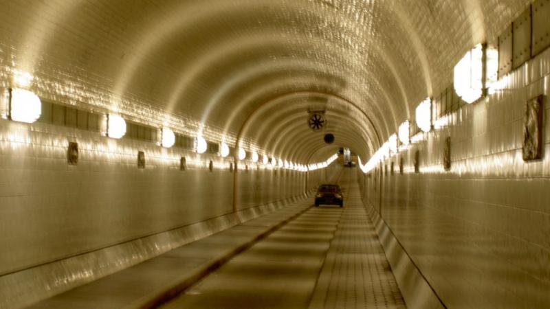 Lange, verlichte tunnel met één auto, als beeld voor tunnelvisie.
