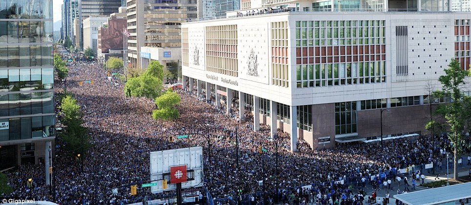 Gigapixelfoto van bovenaf van een enorme menigte fans die een brede straat in het centrum van Vancouver vult, langs een gebouw van de CBC.