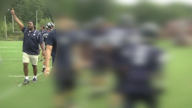 Videobeeld van een man in poloshirt die met opgeheven arm aanwijzingen geeft op een footballveld, met vage spelers op de voorgrond; volgens het artikel gaf de verdachte kort voor de verdwijning footballtraining.