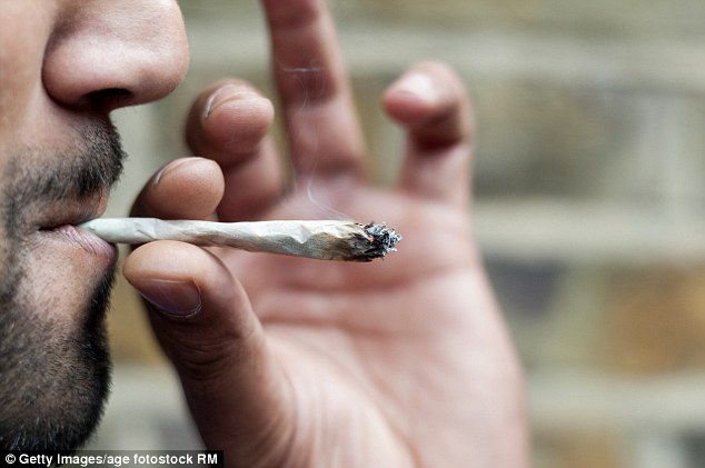 Close-up van een man met baard die een joint rookt.