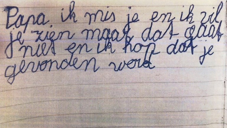 Handgeschreven briefje op gelinieerd papier met de tekst “Papa, ik mis je en ik wil je zien maar dat gaat niet en ik hoop dat je gevonden wordt”.
