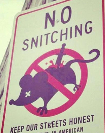 Straatbord met de tekst “No snitching” en een doorgestreepte rat met een mes in zijn rug, met onderaan “Keep our streets honest”.