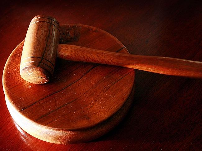 Een houten rechtershamer op een rond houten blok.