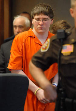 Brendan Dassey, de neef van Steven Avery, in een oranje gevangenisoverall en met handboeien in de rechtszaal.
