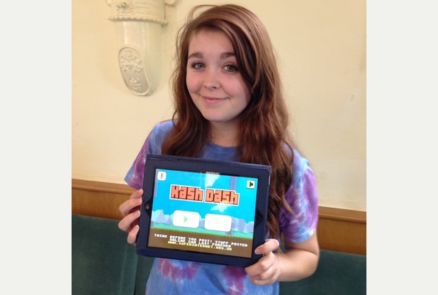 Niamh Pusey (15) houdt lachend een tablet vast met het beginscherm van de game Kash Dash.