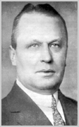 Zwart-wit portret van burgemeester P.J. Reymer van Hilversum, een man met achterovergekamd haar in pak met stropdas.